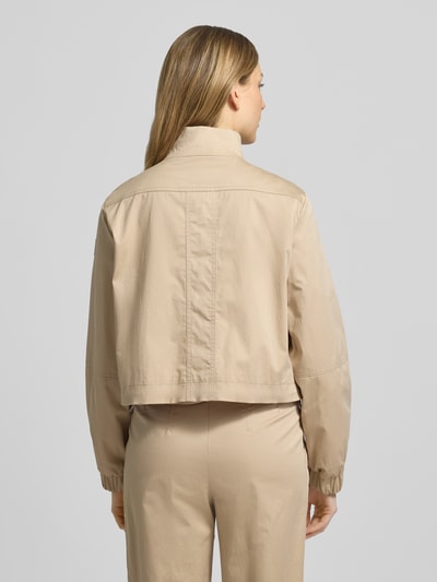 Frauenmodel trägt Regular Fit Jacke mit Stehkragen von Marc Cain in Beige, elastischer Baumwoll-Mix, Pattentaschen, Ganzkörperansicht Rückansicht.