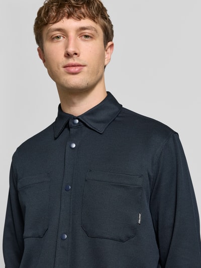 Männermodel trägt Regular Fit Freizeithemd mit Kentkragen Modell 'ADRIAN' von Blend in Dunkelblau, elastischer Material-Mix, Nahaufnahme Oberkörper.