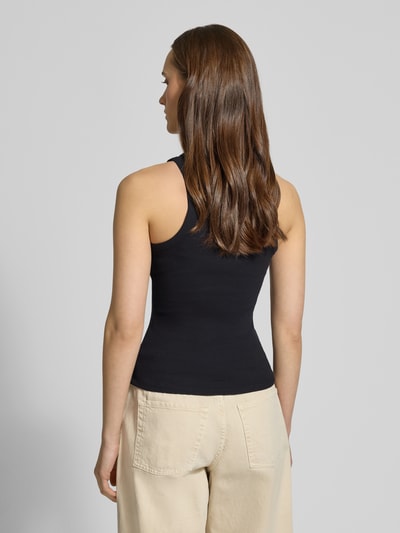 Frauenmodel trägt Tanktop in Ripp-Optik von REVIEW, Baumwoll-Elasthan-Mix, enge Passform, schwarze Farbe, Rückansicht Ganzkörperansicht.
