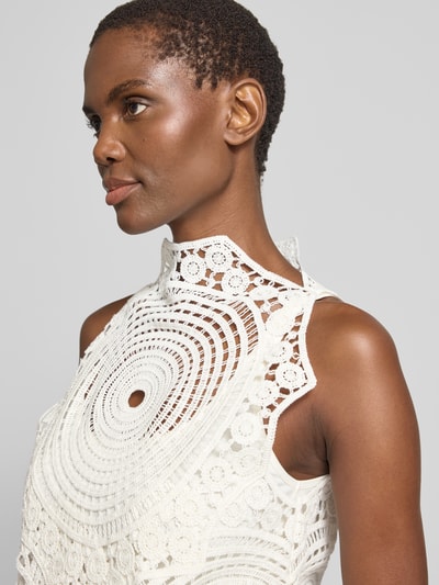 Frauenmodel trägt Stricktop aus Häkelspitze Modell 'CRYSTAL' von Copenhagen Muse in Weiß, Reine Baumwolle, asymmetrischer Schnitt, Nahaufnahme Oberkörper.