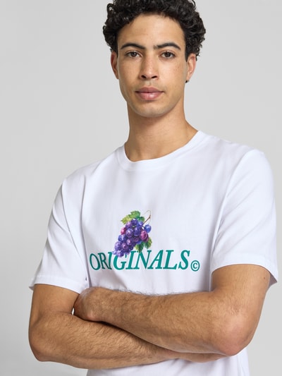 Männermodel trägt Regular Fit T-Shirt mit Statement-Print Modell 'Eres' von Jack & Jones aus reiner Baumwolle, Nahaufnahme Oberkörper.