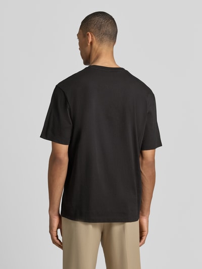 Männermodel trägt Regular Fit T-Shirt aus reine Baumwolle Modell 'DAMORU' von HUGO, unifarben schwarz, kurzarm, Rückansicht Ganzkörperansicht.