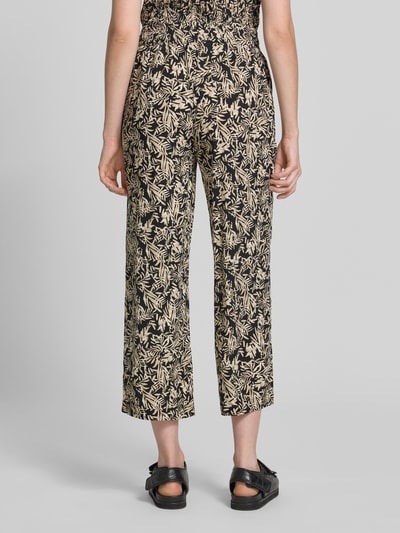 Frauenmodel trägt Straight Fit Stoffhose aus reiner Viskose-Mix Modell 'Faye' von Soyaconcept, floraler Allover-Print, verkürzte Passform, elastischer Bund mit Tunnelzug, Ganzkörperansicht Rückansicht.