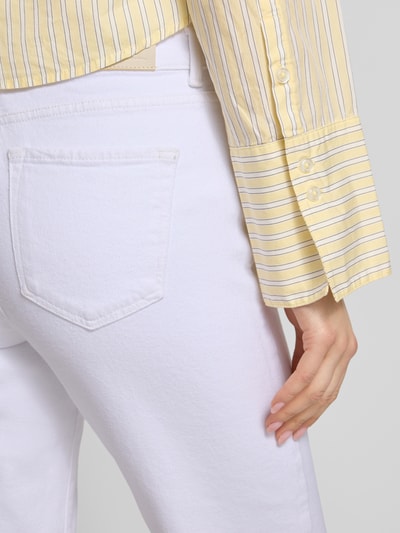 Kobieta nosi Straight Fit Jeans aus Baumwoll-Mix Modell 'EMILY' odzież damska, biała, 5 kieszeni, label patch, krój straight fit, high waist, detal tylnej kieszeni, materiał bawełniany, detal guzika, widok z tyłu, zbliżenie na górną część ciała.