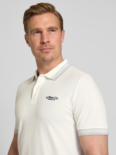 Männermodel trägt Regular Fit Poloshirt aus Baumwoll-Mix von s.Oliver RED LABEL in Optik: Unifarben, mit Label-Print, Nahaufnahme Oberkörper.