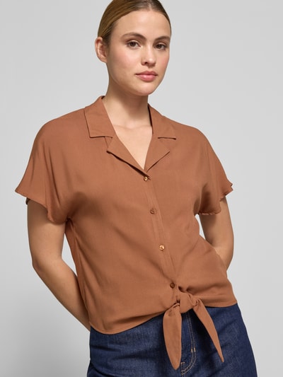 Frauenmodel trägt Regular Fit Bluse aus Viskose mit Knotendetail Modell 'RADIA' von Soyaconcept in Braun, Reverskragen, Knopfleiste, Nahaufnahme Oberkörper. Rückenlänge bei Größe S: 55 cm, Ärmellänge bei Größe S: 10 cm, glatte Textur.