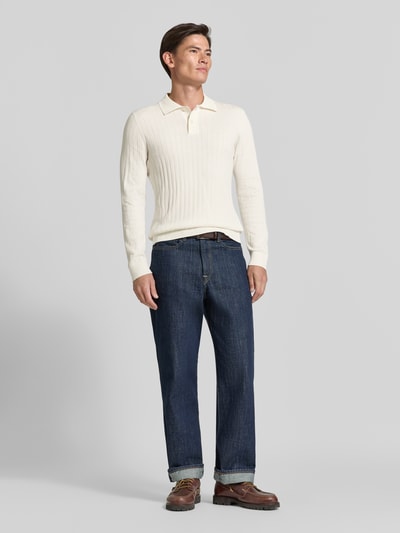 Männermodel trägt Regular Fit Poloshirt aus reiner Baumwolle Modell 'TORINO' von Selected in Offwhite, schlichter Hintergrund, Ganzkörperansicht von vorne, Herren Poloshirt von Selected.