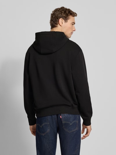 Männermodel trägt Regular Fit Hoodie aus reiner Baumwolle Modell 'DAPO' von HUGO, unifarben, mit Kapuze, Ganzkörperansicht Rückansicht