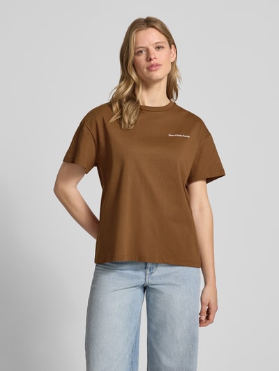 Frauenmodel trägt Relaxed Fit T-Shirt aus reiner Baumwolle - Special Drop von Marc O'Polo Denim, unifarben braun, Rundhals, kurzarm, mit Label-Print, Ganzkörperansicht von vorne.
