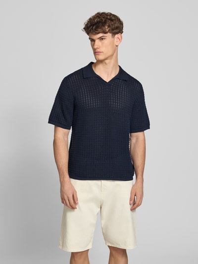 Männermodel trägt Regular Fit Poloshirt mit V-Ausschnitt von Jack & Jones aus reiner Baumwolle als Strickshirt, marineblau, Ganzkörperansicht von vorne.