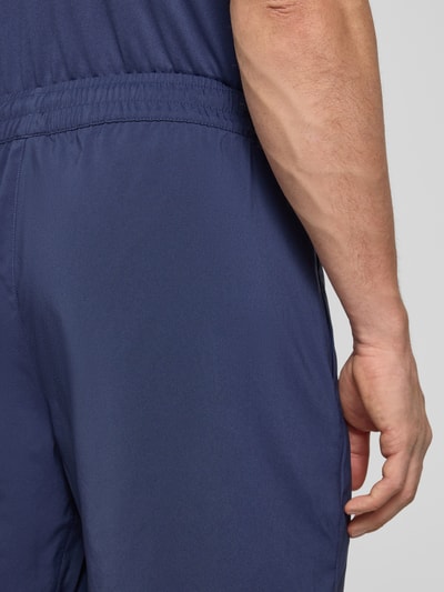 Männermodel trägt Shorts mit Logo und elastischem Bund von PUMA PERFORMANCE in Dunkelblau, glatte Textur, Detailaufnahme Rückansicht.