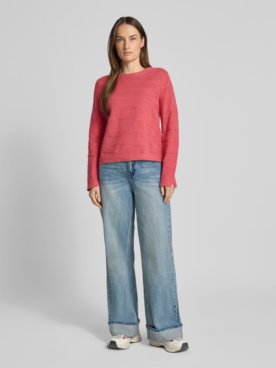 Modelka nosi Regular Fit Pullover aus reiner Baumwolle von Tom Tailor w kolorze malinowym, strukturalny wzór, długi rękaw, okrągły dekolt, prążkowane wykończenie, dzianina z czystej bawełny, widok całej sylwetki z przodu.