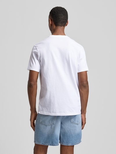Männermodel trägt T-Shirt mit Rundhalsausschnitt Modell 'DEN' von CINQUE in Weiß zu Jeansshorts, reine Baumwolle, Ganzkörperansicht Rückansicht.