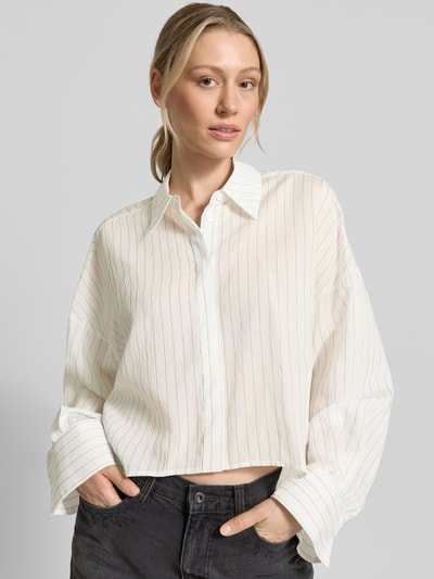 Vrouwenmodel draagt Relaxed Fit blouse met verdekte knoopsluiting model 'OSHIA' van Drykorn, lyocellmix, overhemdkraag, ruglengte maat 36: 57 cm, mouwlengte maat 36: 61 cm, wit met fijne strepen, lichte structuur, voorkant bovenlichaam close-up.