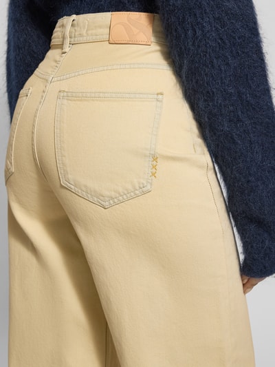 Frauenmodel trägt Jeans mit weitem Bein im Used-Look von Scotch & Soda in Beige aus reiner Baumwolle mit Eingrifftaschen, Detailaufnahme Rückansicht.