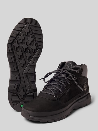 Productfoto, Sneaker uit echt leer model 'Trekker' van Timberland, heren sneakers in leermix met logodetail, afgeronde pasvorm, hakhoogte maat 44: 4 cm, schachthoogte maat 44: 8 cm, schachtbreedte maat 44: 10 cm, zwart met grove zool en textuur.