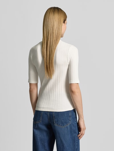 Kobiece model prezentuje damski t-shirt w kolorze kremowym o efekcie prążkowania z okrągłym dekoltem, mieszanka materiałów z dodatkiem streczu, krój slim fit, model 'Savka' od OPUS, długość tyłu w rozmiarze 36: 56 cm, całkowity widok z tyłu.