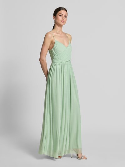 Frauenmodel trägt Maxikleid aus fließendem Stoff Modell 'Cathleen' von GUIDO MARIA KRETSCHMER WOMAN in zartem Grün, taillierter Schnitt, Wickel-Optik, verstellbare Spaghettiträger; Ganzkörperansicht von vorne.