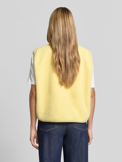 Frauenmodel trägt Relaxed Fit Weste aus Teddyfell Modell 'Hoktown' von American Vintage, gelb, Rückenansicht, Damen Weste, KI-modifiziertes Bild.
