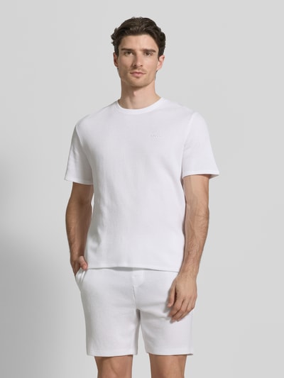Männermodel trägt Regular Fit Pyjama-Oberteil aus Baumwoll-Mix Modell 'WAFFLE' von BOSS in Optik: Unifarben mit Label-Stitching-Applikation, Rundhals-Ausschnitt, Kurzarm, Materialverarbeitung: Piqué, Ganzkörperansicht von vorne.