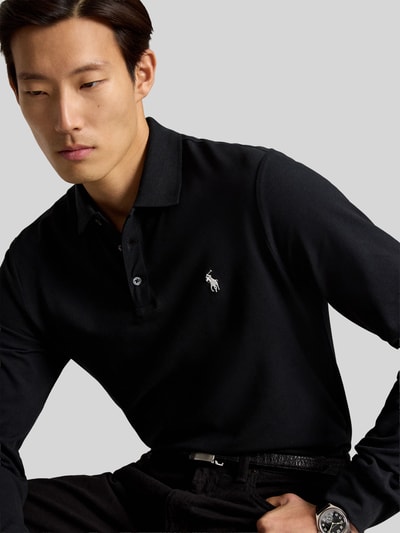 Männermodel trägt Regular Fit Poloshirt mit Logo-Stitching von Polo Ralph Lauren in Schwarz, glatte Textur, Nahaufnahme Oberkörper, Herren Pullover von Polo Ralph Lauren.