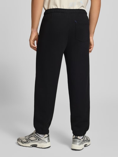 Männermodel trägt zwarte Regular fit Sweathose uit pure katoen model 'Nivion' van HUGO, Heren Sweathose, Ganzkörperansicht Rückansicht.