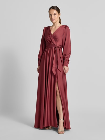 Frauenmodel trägt Tailliertes Abendkleid mit Bindegürtel von Jake*s Cocktail in Bordeauxrot, fließendes Material, Ganzkörperansicht von vorne.