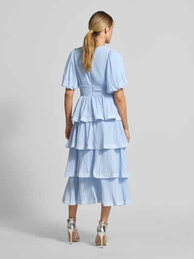 Frauenmodel trägt Midikleid in Rüschen-Optik Modell 'Plira' von YAS in Hellblau mit Strukturmuster, Taillierte Passform, Ganzkörperansicht Rückansicht.
