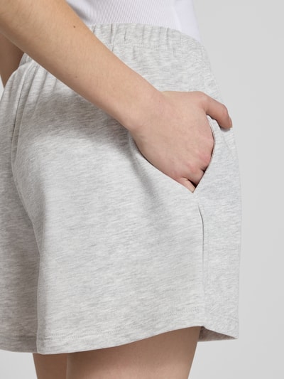 Frauenmodel trägt Kurze Sweatshort mit Stickerei von REVIEW aus Baumwoll-Viskose-Mix, hellgrau, elastischer Bund, Nahaufnahme Oberkörper.
