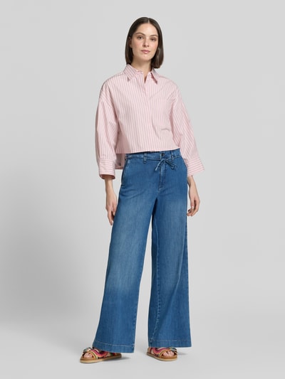 Modelka nosi Wide Leg Jeans mit Bindegürtel Modell 'WENDY' od MAC, bawełna z elastanem, szerokość w rozmiarze 36/32: 43 cm, długość nogawki wewnętrznej 82 cm, jeansy niebieskie, widok całej sylwetki z przodu.