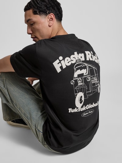 Männermodel trägt schwarzes Relaxed Fit T-Shirt aus reiner Bio-Baumwolle Modell 'FRED' von Only & Sons mit weißem Rücken-Print, unifarbenes Design, Nahaufnahme Rückansicht.