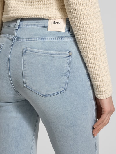 Frauenmodel trägt helle Bootcut Jeans mit Fransen Modell 'SHAKIRA' von Brax, Baumwoll-Mix, Gesäßtasche, Detailaufnahme Rückansicht.