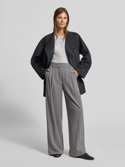 Kobiece model nosi Slim Fit Longsleeve aus Strick-Optik od MYON, imitacja dzianiny, krój slim fit, listwa guzikowa, okrągły dekolt, długość tyłu w rozmiarze 36: 60 cm, długość rękawów w rozmiarze 36: 66 cm, widoczne od przodu całe ciało.