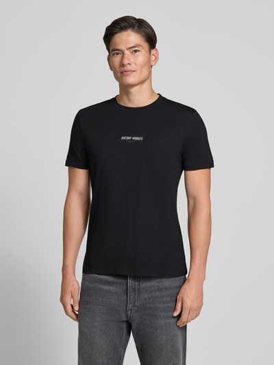 Männermodel trägt Regular Fit T-Shirt mit Label-Print von Antony Morato, schwarze Baumwolle, Rundhalsausschnitt, Ganzkörperansicht von vorne.