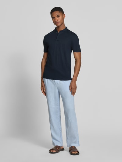 Männermodel trägt Slim Fit Poloshirt mit Stehkragen Modell 'LOUIS' von Drykorn aus Baumwoll-Modal-Mix, Dunkelblau, Ganzkörperansicht von vorne, Rückenlänge bei Größe M 69 cm.