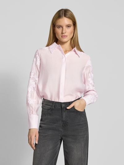 Frauenmodel trägt Relaxed Fit Bluse mit Spitze und verdeckter Knopfleiste von Copenhagen Muse in zartem Rosa, Kombination aus glatter und Spitzenstruktur, Hemdblusenkragen, Ganzkörperansicht von vorne.