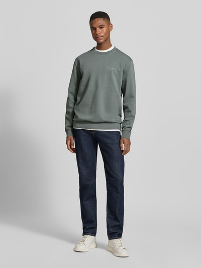 Männermodel trägt Regular Fit Sweatjacke aus reiner Baumwolle von Marc O'Polo in Unifarben, Crew Neck, gerippte Abschlüsse, Nahaufnahme Ganzkörperansicht von vorne.