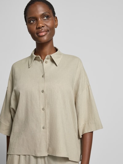 Frauenmodel trägt Relaxed Fit Bluse aus Leinen-Viskose-Mix von Drykorn in Beige, glatte Textur, Kentkragen, Knopfleiste, Nahaufnahme Oberkörper, Damen Bluse Modell 'YARIKA', Rückenlänge bei Größe 36: 55 cm, Ärmellänge bei Größe 36: 23 cm, überschnittene Schultern.
