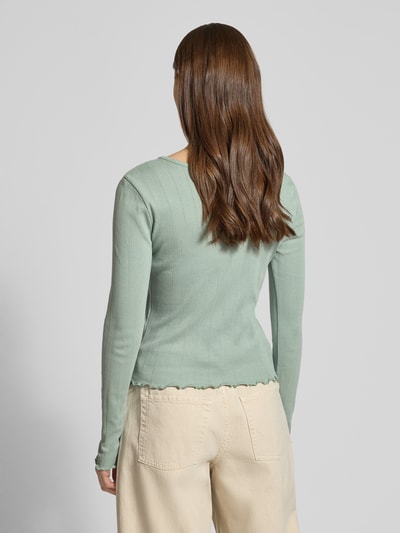 Frauenmodel trägt Slim Fit Langarmshirt aus Bio-Baumwoll-Mix Modell 'TENNA LIFE' von ONLY, Optik: unifarben, feines Lochstrickmuster, Ganzkörperansicht Rückansicht.