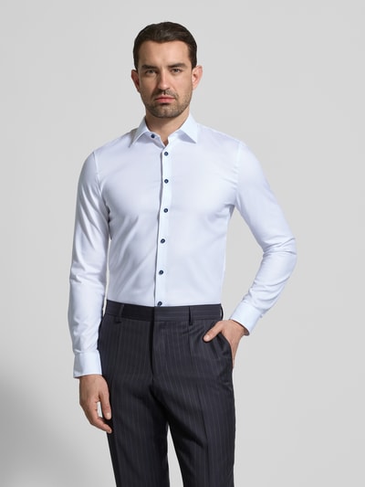 Męski model nosi Super Slim Fit Business-Hemd mit Kentkragen von OLYMP, mieszanka bawełny i elastanu, jednokolorowy, długość tyłu 81 cm, szerokość ramion 44 cm, długość rękawów 68 cm, widok na cały przód.