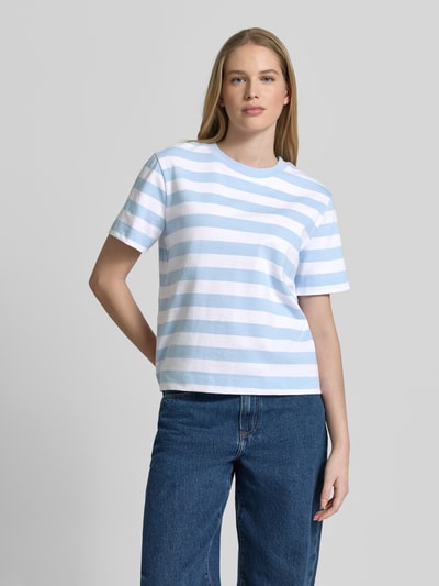 Modelka nosi damski t-shirt Boxy Fit T-Shirt aus reiner Baumwolle Modell 'ESSENTIAL' von Selected Femme, efekt: wzór w paski, naszywka z logo, okrągły dekolt, krótki rękaw, wykończenie materiału: heavy jersey, materiał: czysta bawełna, jasnoniebiesko-białe pasy, widok całej sylwetki z przodu.