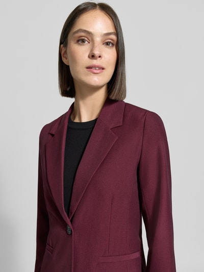 Frauenmodel trägt Blazer mit Viskose-Anteil Modell 'Danta' von b.young in Bordeauxrot, glatte Textur, Nahaufnahme Oberkörper. Elastischer Material-Mix, taillierte Passform, Reverskragen und Knopfverschluss sind erkennbar, Kontext Damen Blazer, Rückenlänge 66 cm, Brustweite 47 cm, Ärmellänge 58 cm.