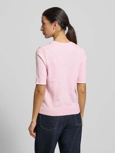 Modelka kobieta ma na sobie Regular Fit Strickpullover mit Rundhalsausschnitt od More & More, różowy, półrękawy, z elastycznymi zakończeniami, mieszanka wiskozy, widok całej sylwetki od tyłu.
