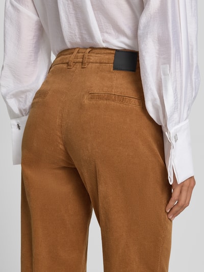 Vrouwenmodel draagt Cordhose met opgerolde zoom van Marc Cain in katoenmix met stretch, strookzakken achter, detailopname rugaanzicht. Context: Dames corduroy broek van Marc Cain, katoenmix met stretch, slim fit, knoop- en ritssluiting, Franse steekzakken, zoom met omslag, strookzakken aan de achterkant, bandwijdte maat 36: 41 cm, binnenbeenlengte maat 36: 73 cm.