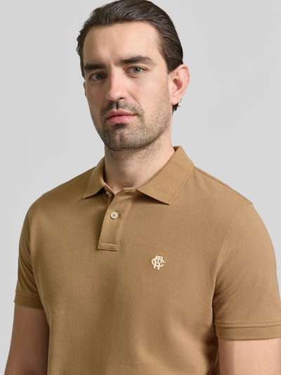 Mannenmodel draagt Slim Fit Poloshirt met Logo-Stitching van MCNEAL, puur katoen, polokraag, lichtbruine kleur, close-up bovenlichaam.