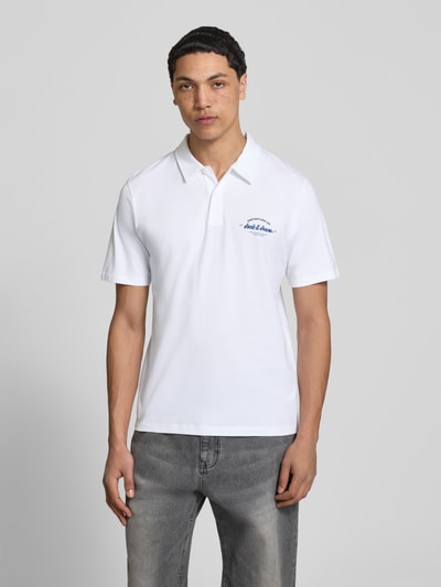 Männermodel trägt weißes Poloshirt mit Label-Print Modell 'BRANDON' von Jack & Jones, reine Baumwolle, Regular Fit, ganzkörperansicht von vorne.
