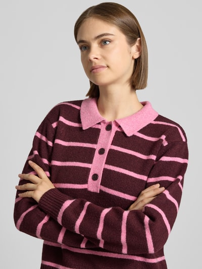 Kobiece model nosi sweter z dzianiny Strickpullover mit Polokragen Modell 'RUBY' od JJXX, mieszanka materiałów z bawełną, luźny krój, kołnierzyk polo, prążkowane wykończenia, długość tyłu w rozmiarze S: 48 cm, długość rękawów: 59 cm, widok górnej części ciała z przodu.