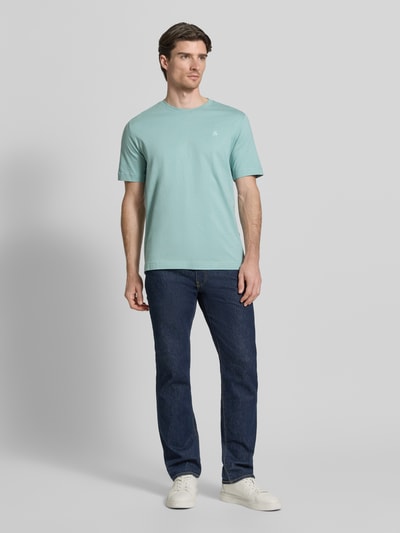 Männermodel trägt Regular Fit T-Shirt aus reiner Baumwolle von Marc O'Polo in Uni-Optik, Logo-Stitching, Kurzarm, Ganzkörperansicht von vorne.