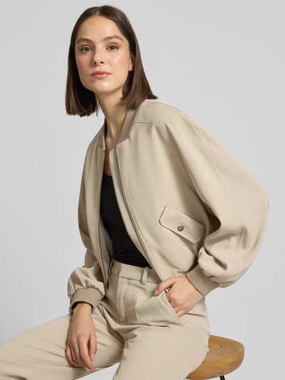 Frauenmodel trägt Jacke mit Pattentaschen Modell 'MARHAM' von Drykorn in Beige, Material-Mix mit Stretch, Regular Fit, Nahaufnahme Oberkörper.