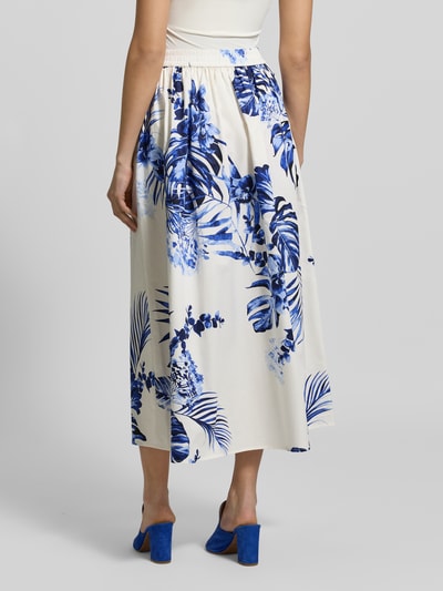 Frauenmodel trägt Midirock im Allover-Look Modell 'TROPICS' von Fynch-Hatton, A-Linie, Reine Baumwolle, florales Muster, Ganzkörperansicht Rückansicht.